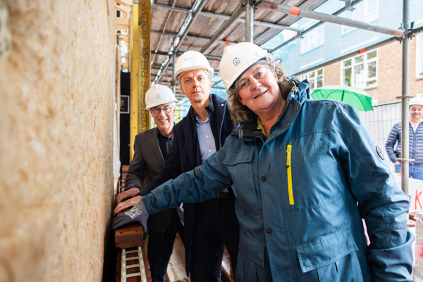 Wethouder Mieke Verhees, Luc Severijnen (directeur-bestuurder ’thuis) en Sander van Doorn (directeur bij Huybregts-Relou) leggen de 'eerste steen'.